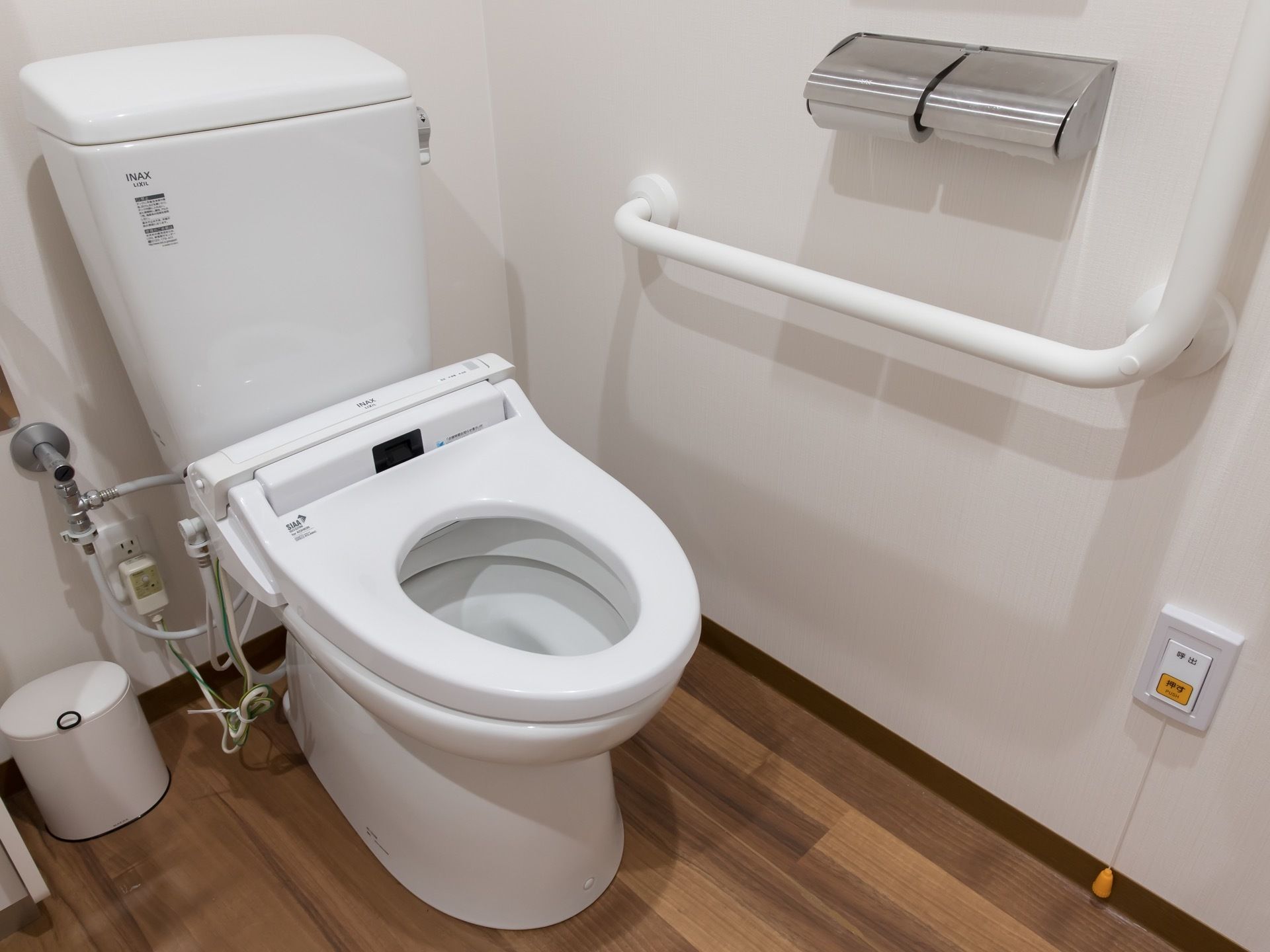 トイレは真っ白で、掃除が行き届いている。温水洗浄機能付きの洋式トイレで、壁にU字の手すりが付いている。非常ボタンが設置してある。