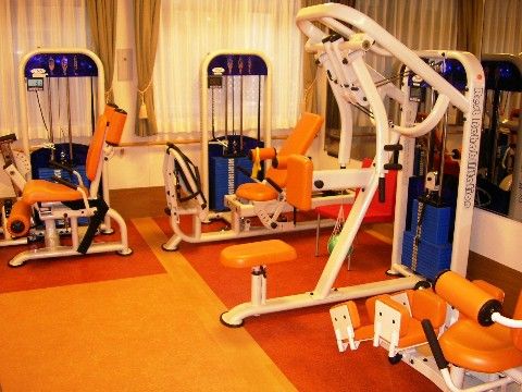 シートがオレンジ色のベンチプレスが多数置いてある機能訓練室