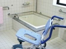 一人用の浴槽が設置された浴室。浴室用車いすもあり、手すりが壁についている。