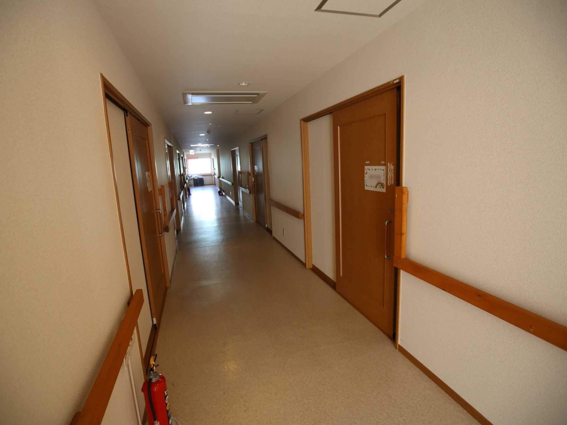 各居室の扉は、大きく開閉する引き戸を設置している。通路には手すりを備え、歩行訓練など安全に行うことができる。