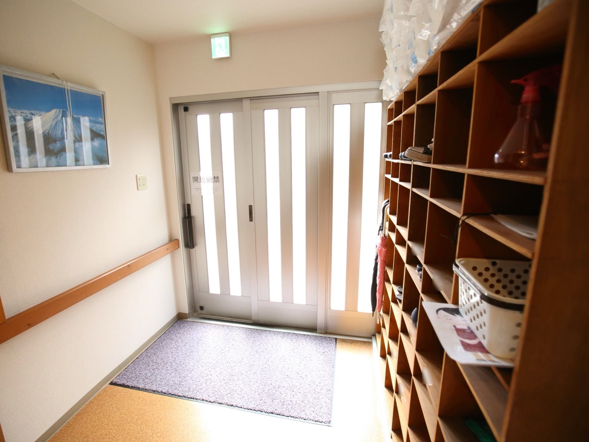 大きな引戸の玄関である。玄関すぐに玄関マットが敷かれ、車椅子や靴の汚れを施設内に持ち込むことなく、清潔である。