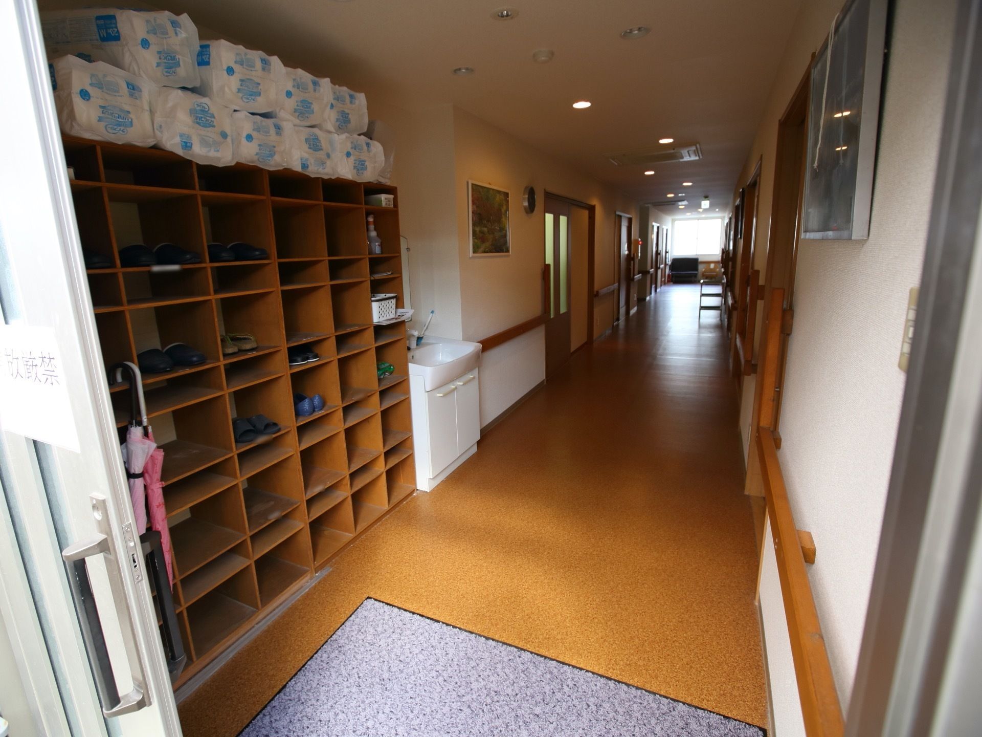 整然として、見通しが良い通路である。玄関すぐに洗面台があり、手洗いが可能である。靴箱も整頓されている。