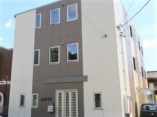 3階建ての建物はすっきりとしたスタイリッシュな外観で、玄関にはポストとホーム名もある。