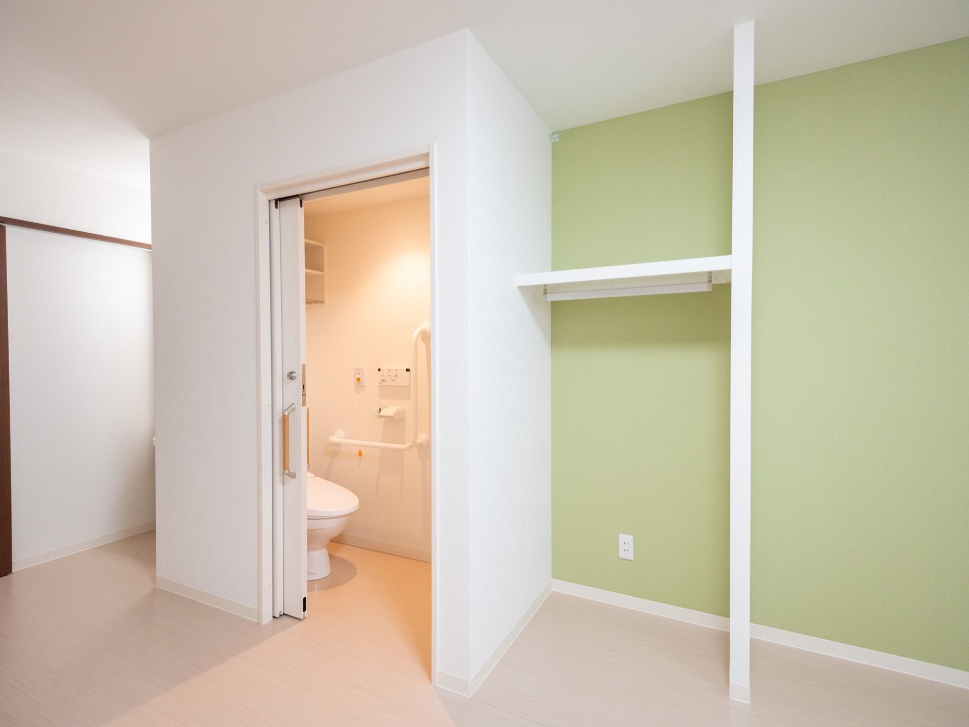 居室には、楽に開閉できる引き戸式のトイレと、オープンな収納スペースが備わっている。部屋全体が段差のない作りになっている。