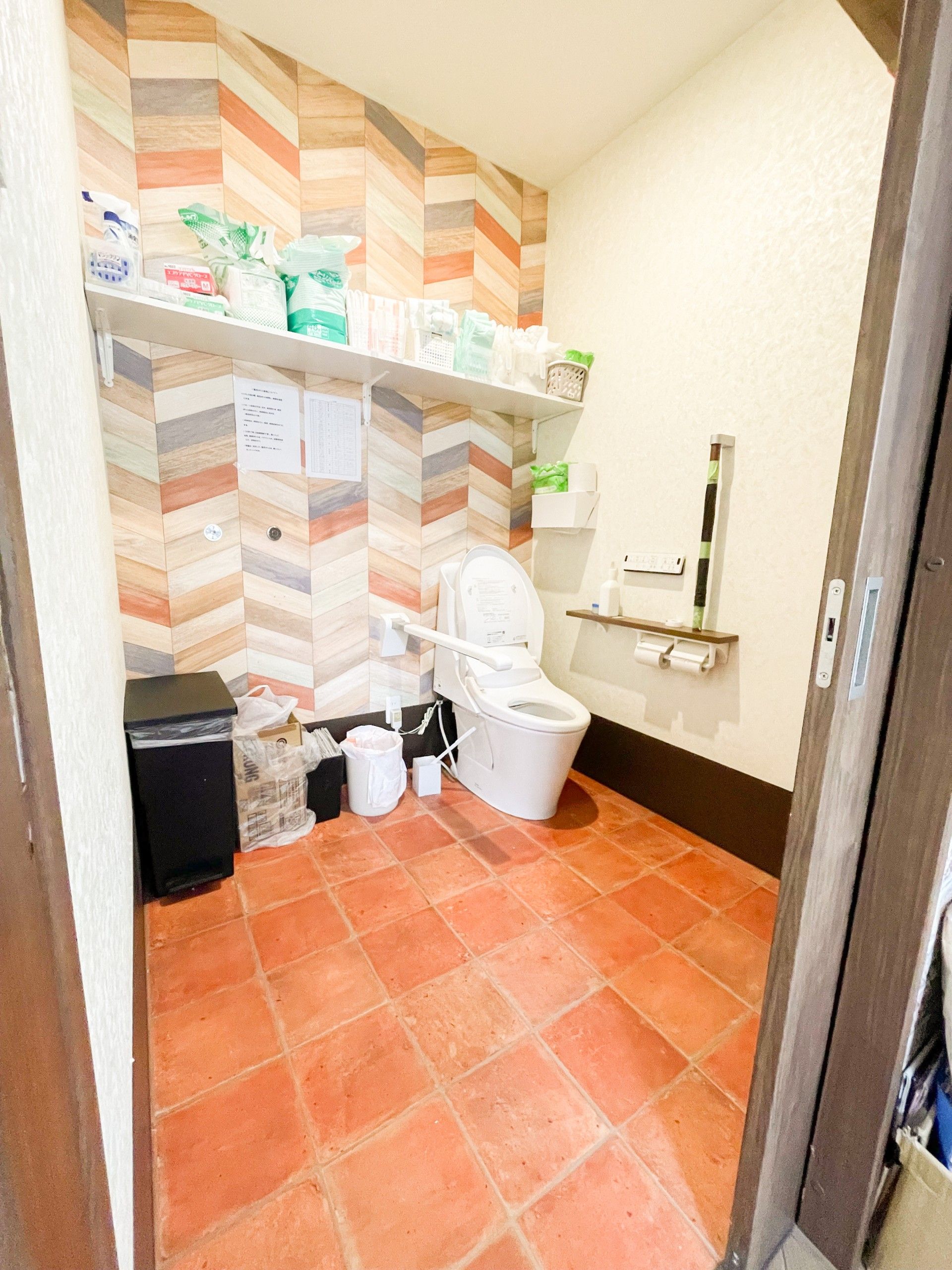 広いスペースが確保されたトイレである。温水洗浄便座が採用されており、操作ボタンが壁に取り付けられている。