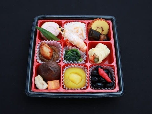 野菜の煮物や厚焼き玉子、海老や栗きんとんの盛り付けられたおせち料理