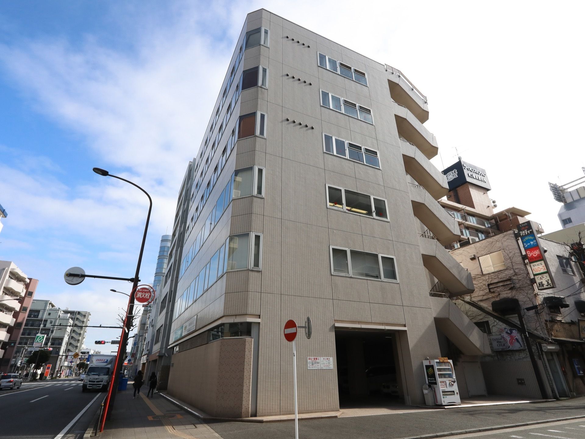 6階建てでマンションを思わせる造りとなっている。車が入るスペースがあり、建物のそばには自動販売機が設置されている。