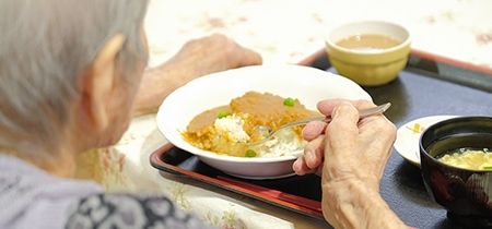 食事をする高齢者の後姿