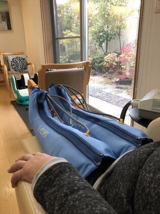 血流をよくする器具を利用しながらリラックスしている高齢者の足元