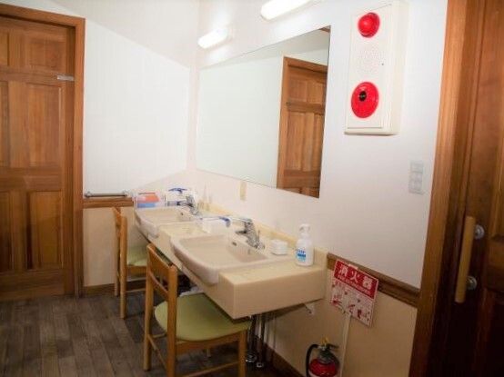 消火器などの防火設備が導入された館内には、車いす対応の洗面所があり、椅子がセットされている。