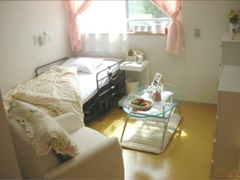 車いすに乗った男性とその人に話しかけている女性。家族で話している様子を写した写真