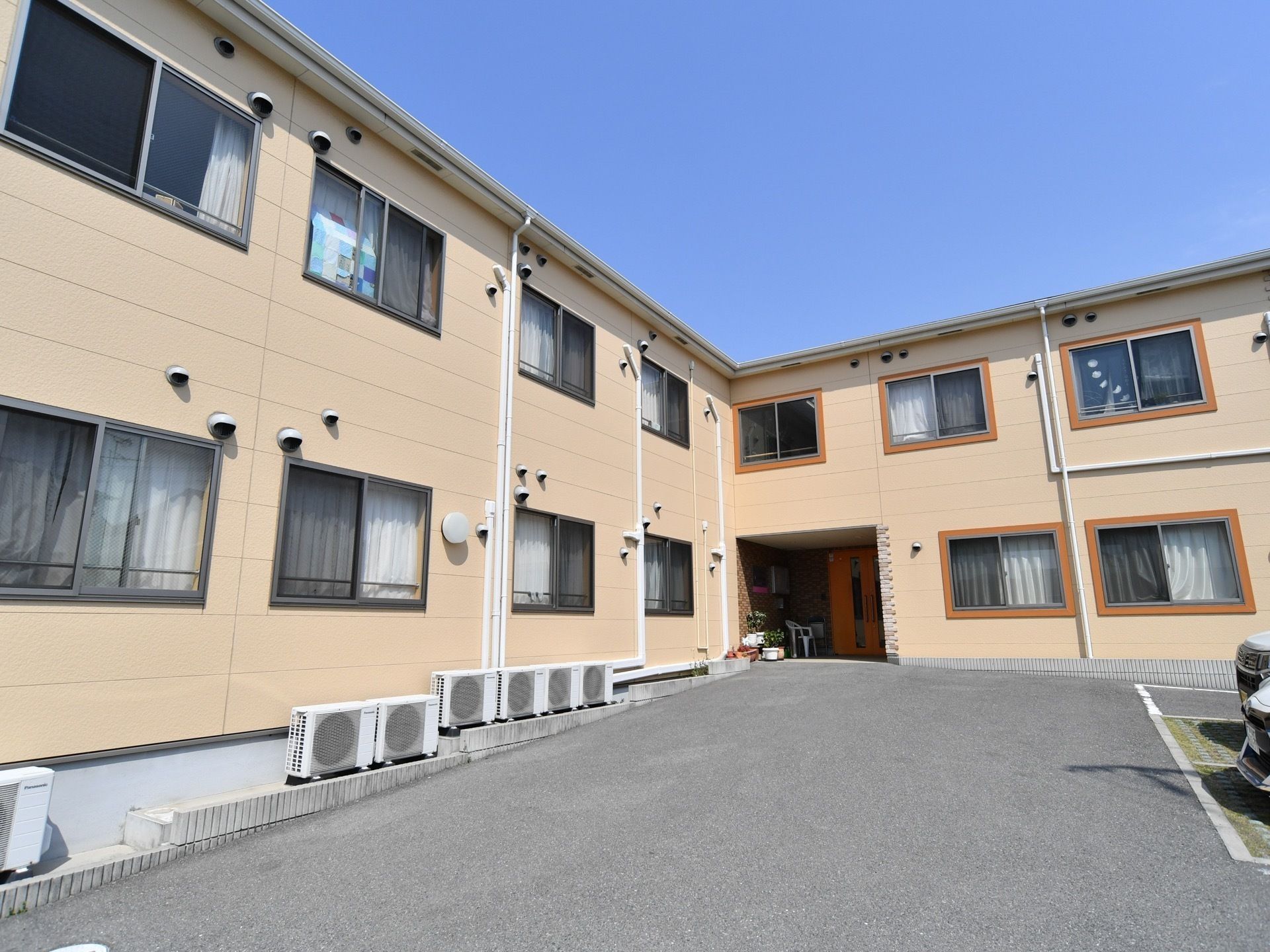 建物の外壁は、全体的に明るいクリームイエローのタイル状になっており、ナチュラルな雰囲気であたたかみがある。