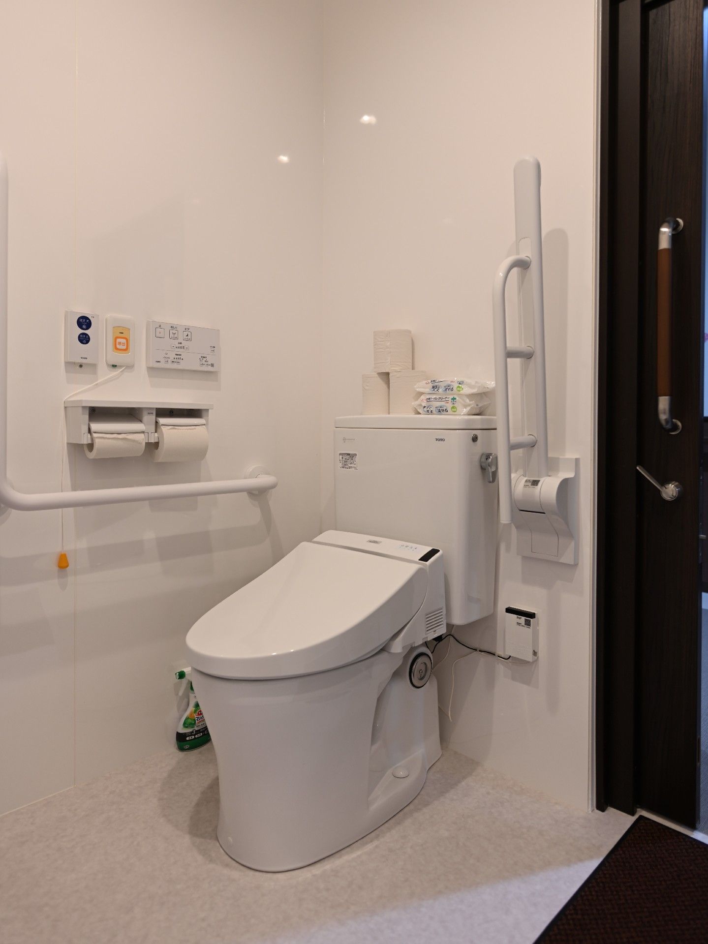 手すりや呼び出しボタンが付いたトイレはシンプルな造り。介助スペースが広くてドアはスライド式。