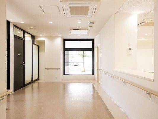 施設内の共有スペースを写した写真。廊下と左側に個室の入り口が見えている様子