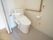 スライド式の扉の奥にあるトイレとL字の手すりが付いた部屋
