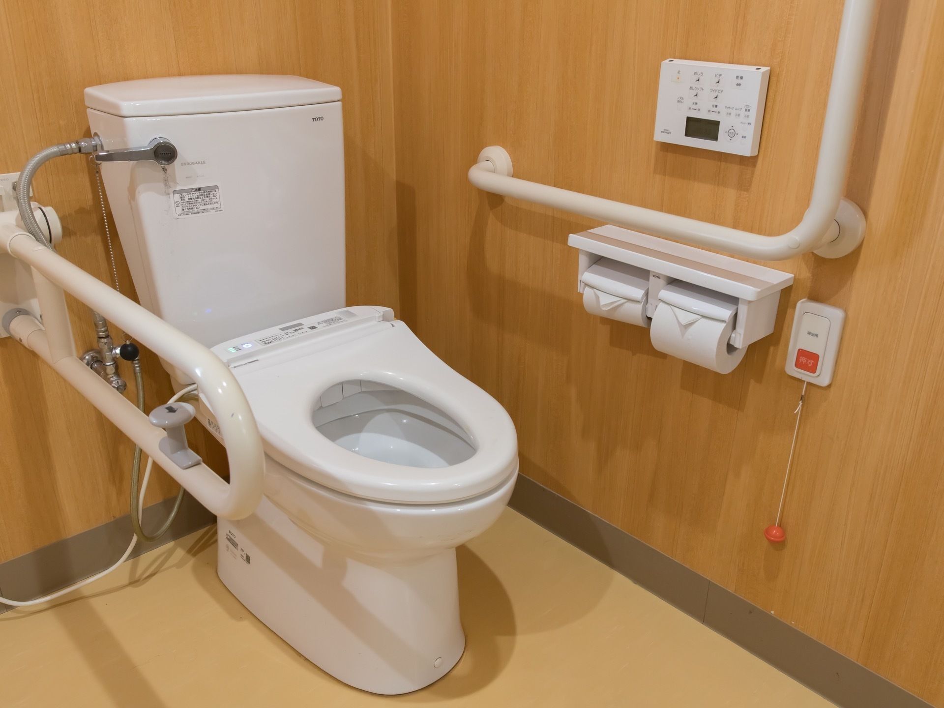木のぬくもりが感じられる清潔感のあるトイレ。温水洗浄機能付き便座が採用されており、両サイドには手すりが設置されている。