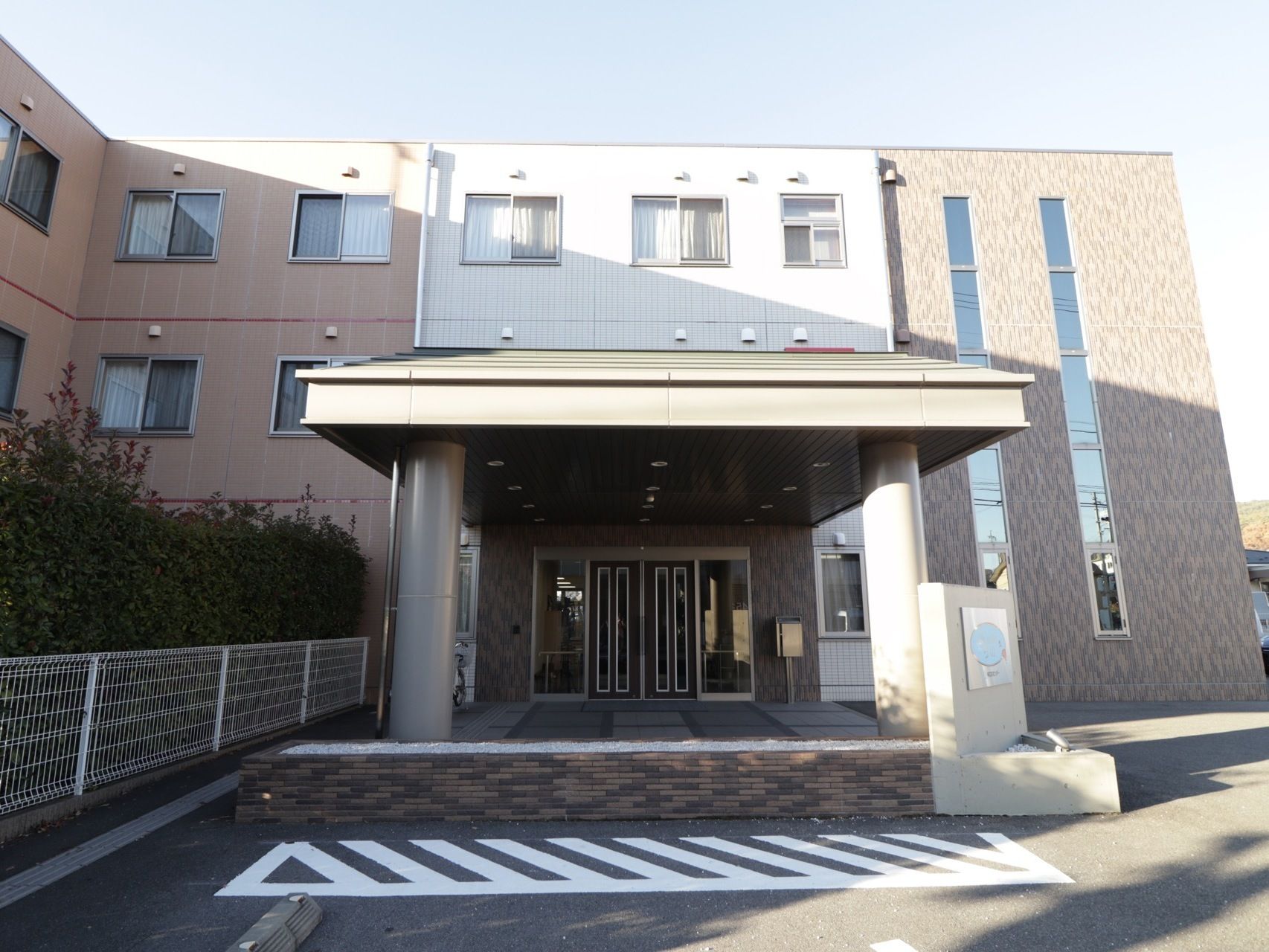 施設は３階建ての建物である。屋根付きのエントランスが設けられており、建物前が駐車スペースになっている。