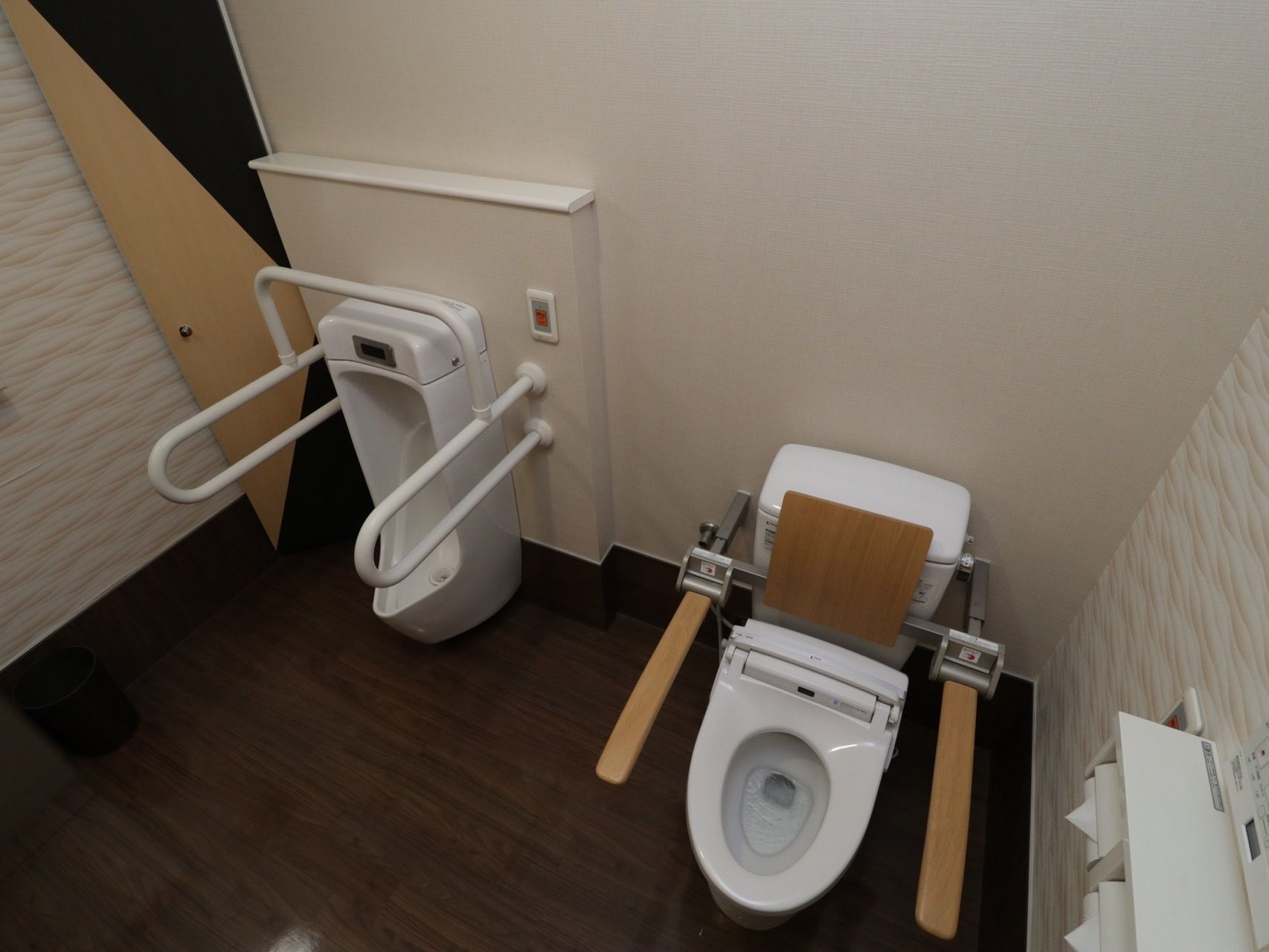 共用トイレは広々としたスペースが確保されている。洋式便器と男性用小便器が完備されており、手すりが設置されている。