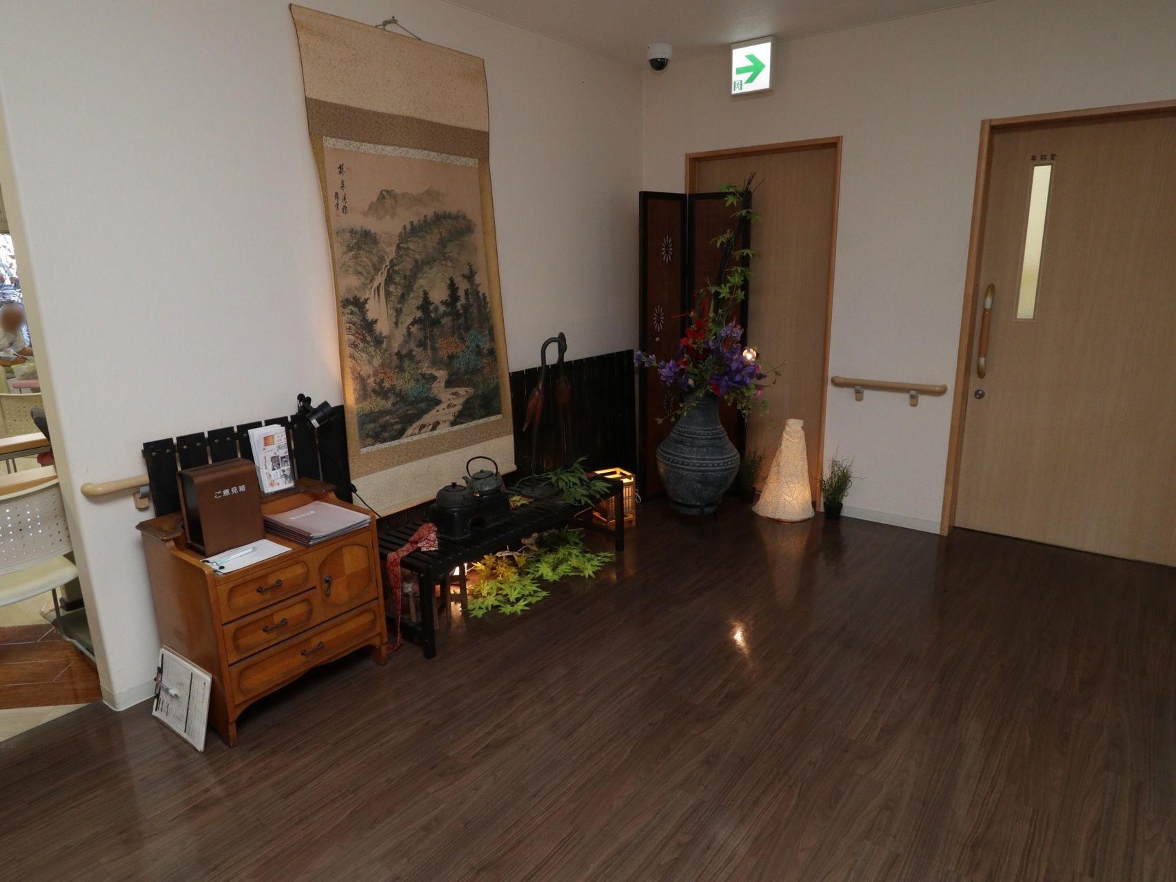 空間にゆとりを持たせたエントランスホールである。壁際には、掛け軸や紅葉といった和風の飾りつけがされている。