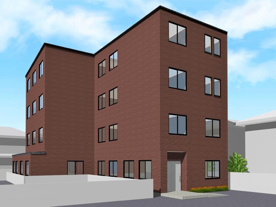 4階建ての建物はブラウン系で玄関のそばには花壇があり、日当たりのいい場所に建っている。