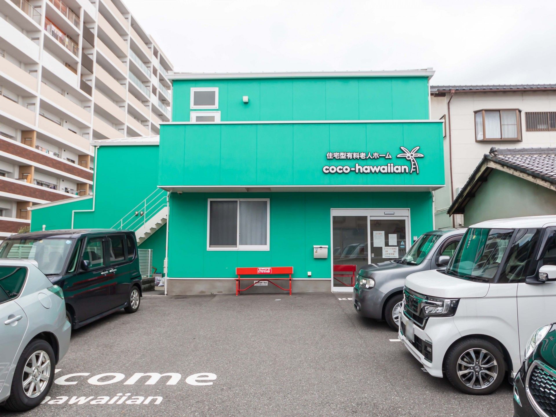施設外観。広々とした駐車場にはWelcomeの文字が書かれており、気軽に立ち寄りやすい。