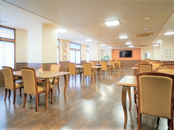木製のテーブルセットが複数並んだ食堂は明るい雰囲気で、大きなテレビも付いている。