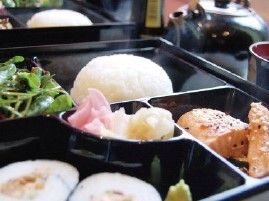 巻き寿司や焼き魚やサラダが入ったお弁当