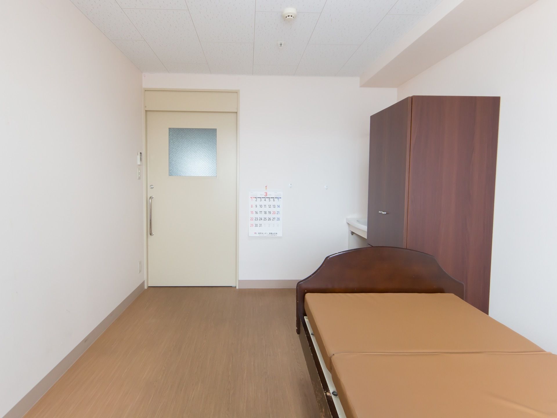 居室のスライドドアを開けると、左手にクローゼットやベッドといった家具が配置されている。右側は通路として場所が空けてある。