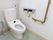 トイレは清潔感のある白い内装でまとめられ、利用しやすい雰囲気になっている。安全のため、壁にはL字型の手すりと呼び鈴を取り付けてある。