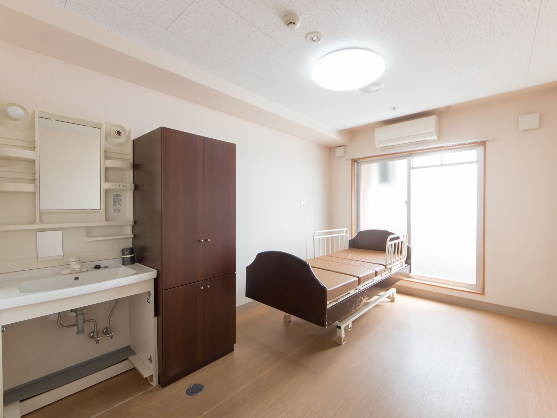 居室の奥にはベランダに面した窓があり、日が良く入り室内は明るい。緊急時のため、ナースコールが標準装備されている。