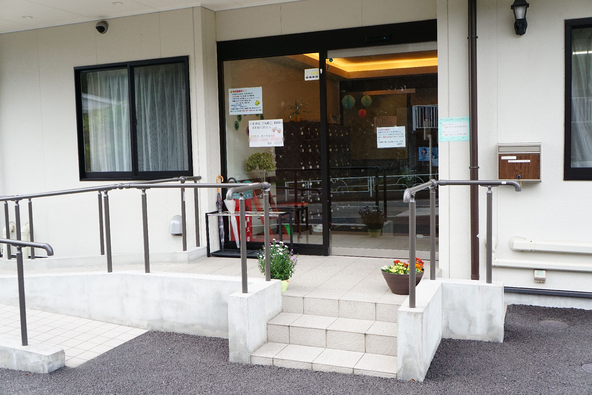 手すりが設置され、階段とスロープが設置されている玄関