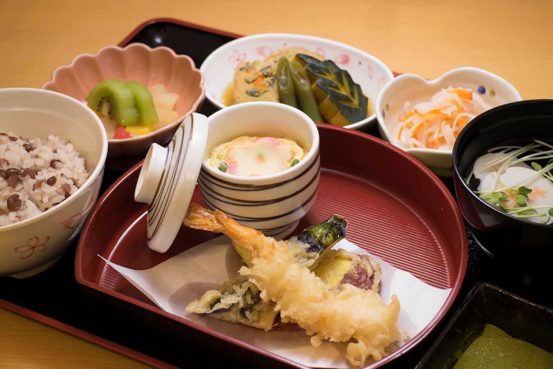 赤飯と吸い物、天ぷらと茶碗蒸し、野菜の煮物やフルーツのデザート
