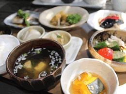 かぼちゃの煮物やトマトときゅうりのサラダが並んだ食事