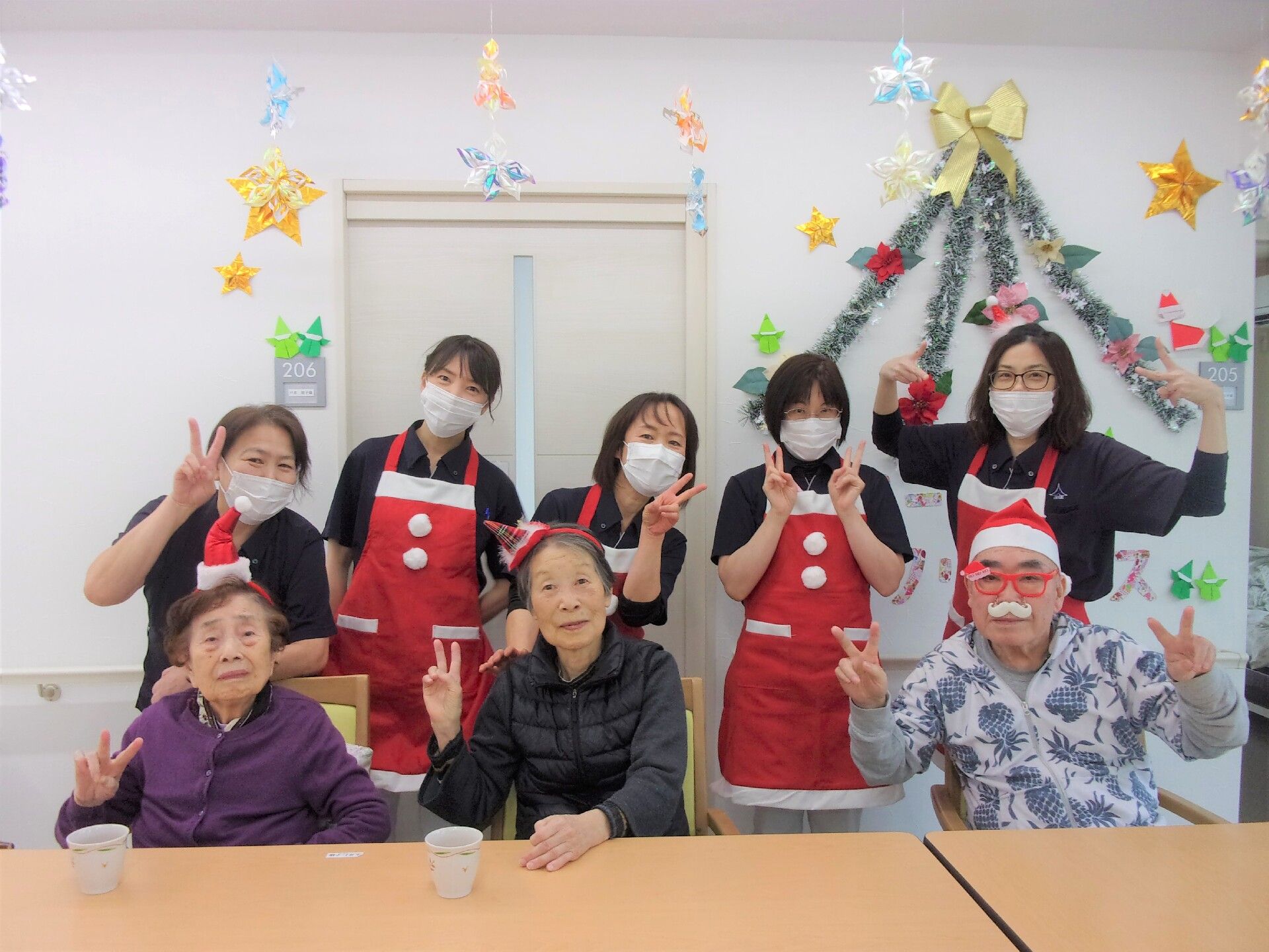 サンタの格好をしたスタッフと一緒に写真に納まる高齢者の様子