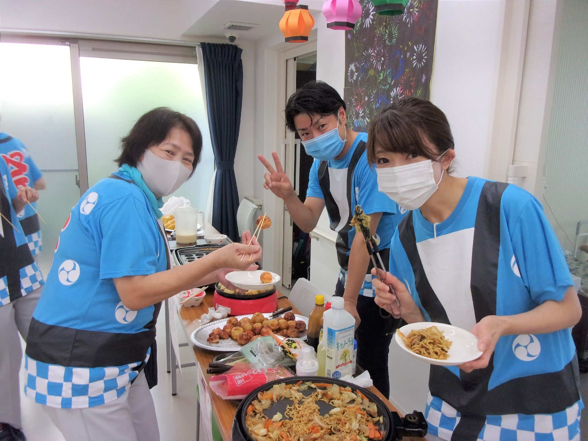 夏の特別食が並ぶテーブルとその前でポーズをとっているスタッフの様子