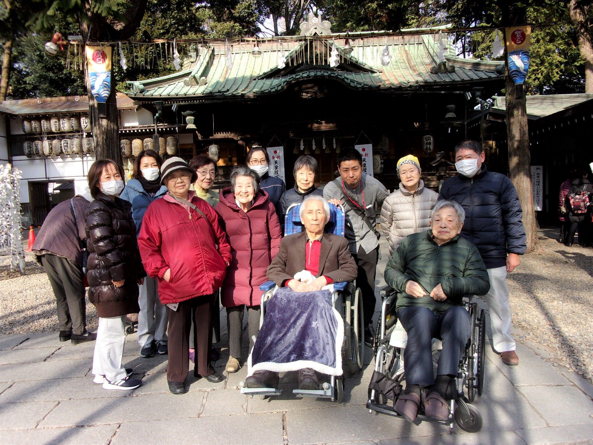 外出イベントで外に出て写真に納まる高齢者とスタッフの様子
