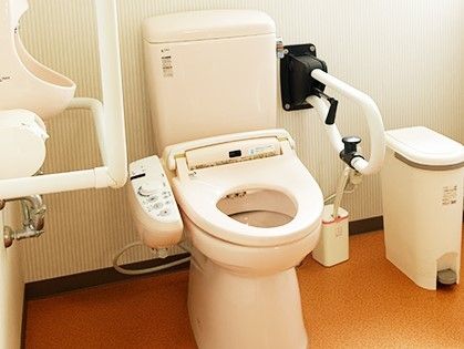 立ち上がりや移動を助ける手すりがついた介護仕様のトイレの様子。車いすでも入れる広さのトイレ