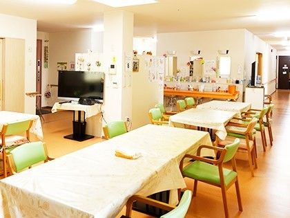 椅子と長机が並んでいる施設内の食堂の様子。横に広いホールの写真