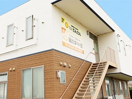 ツートンカラーに塗られた施設の外観写真。通常の住宅のような設計の施設