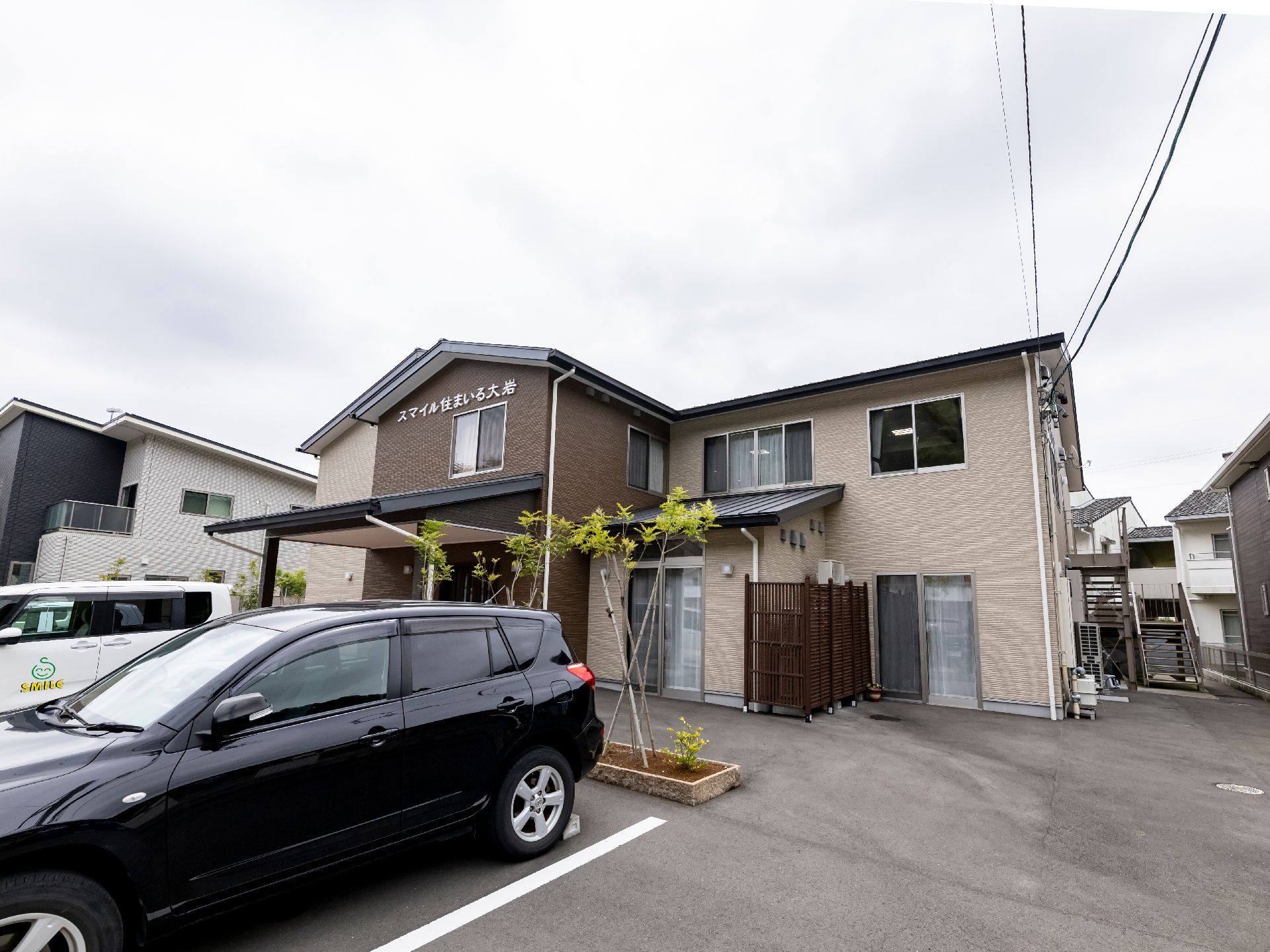 駐車場が隣接している茶色い屋根の介護施設