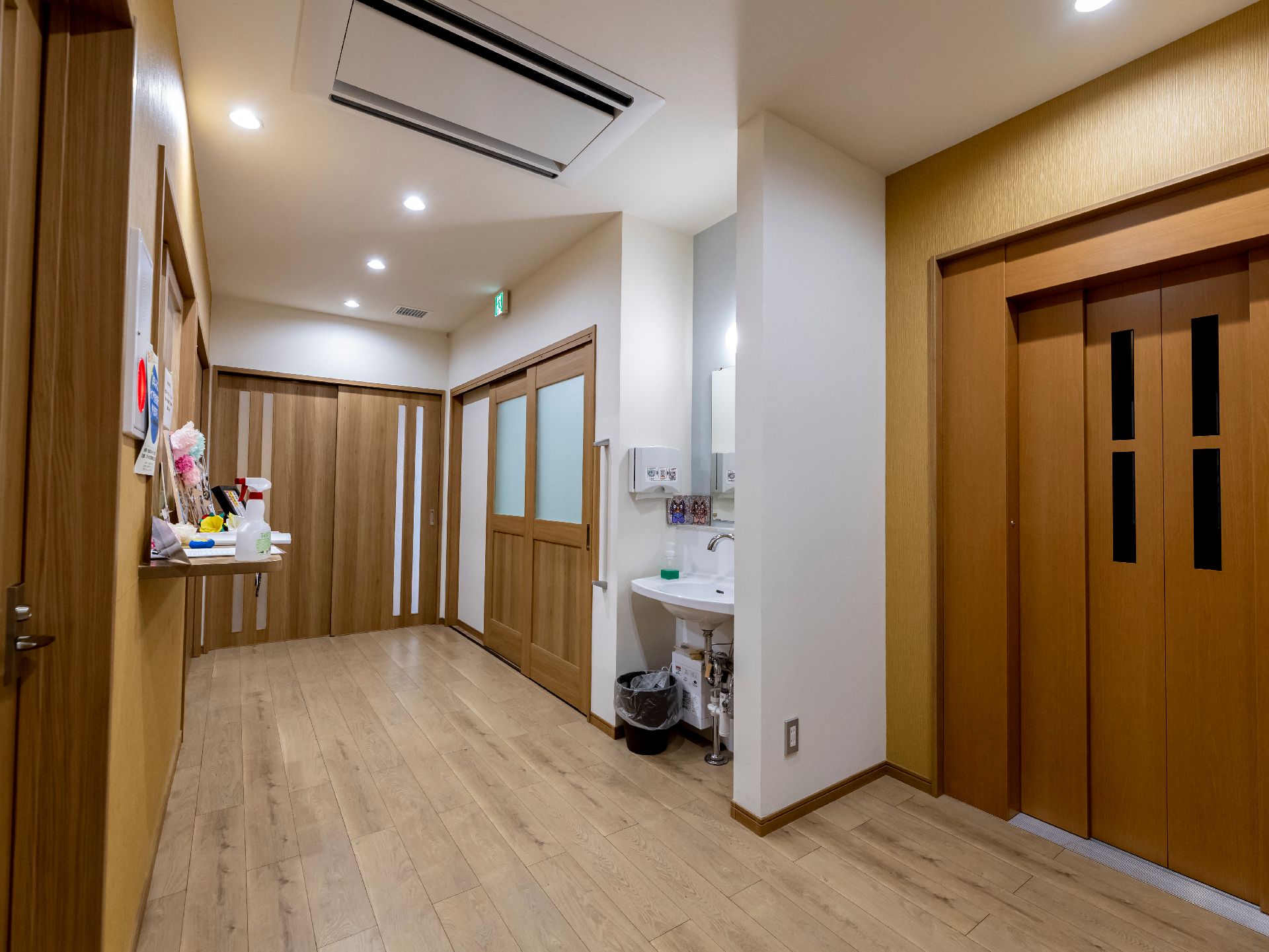 ベージュのエプロンを付けた女性スタッフに付き添われて屋外で楽しそうに過ごしている高齢女性。高齢女性は車いすに座っている。
