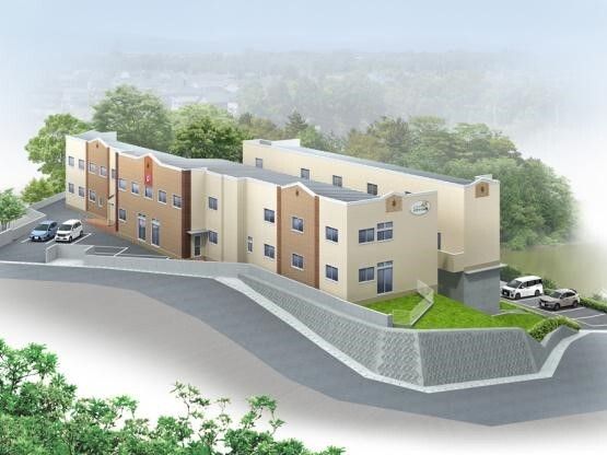 ベージュやブラウンの外壁の２階建ての建物。敷地内には駐車場あり、周りには緑に囲まれている。
