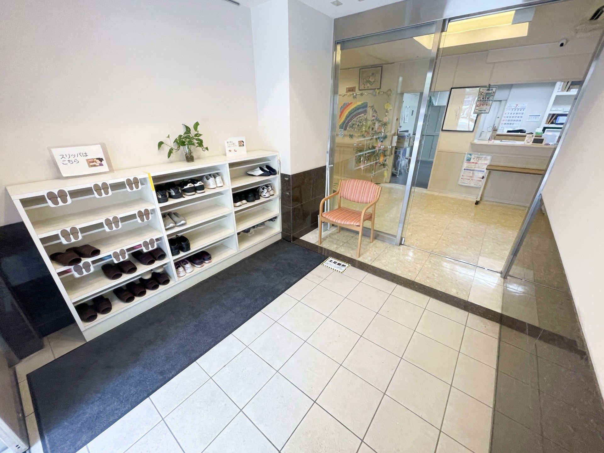 スリッパ棚と椅子のある入口