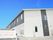2階建ての建物。２階部分はダークグレー、１階部分は白で、ななめ屋根が付いている。