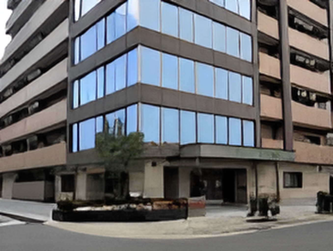 ブラウン系の９階建ての建物は各フロアにベランダがあり、角には大きな窓が付いている。玄関先には車寄せもある。