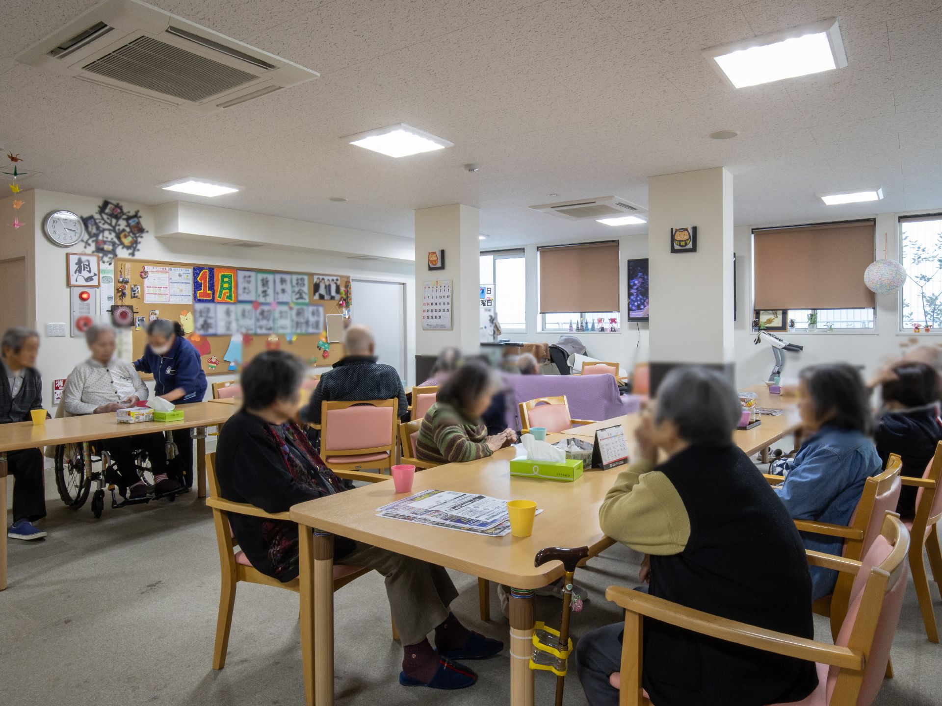 広間に並べられたテーブルを囲んで、たくさんの人々が座っている。壁面に飾られた創作物が、楽しい雰囲気を演出している。