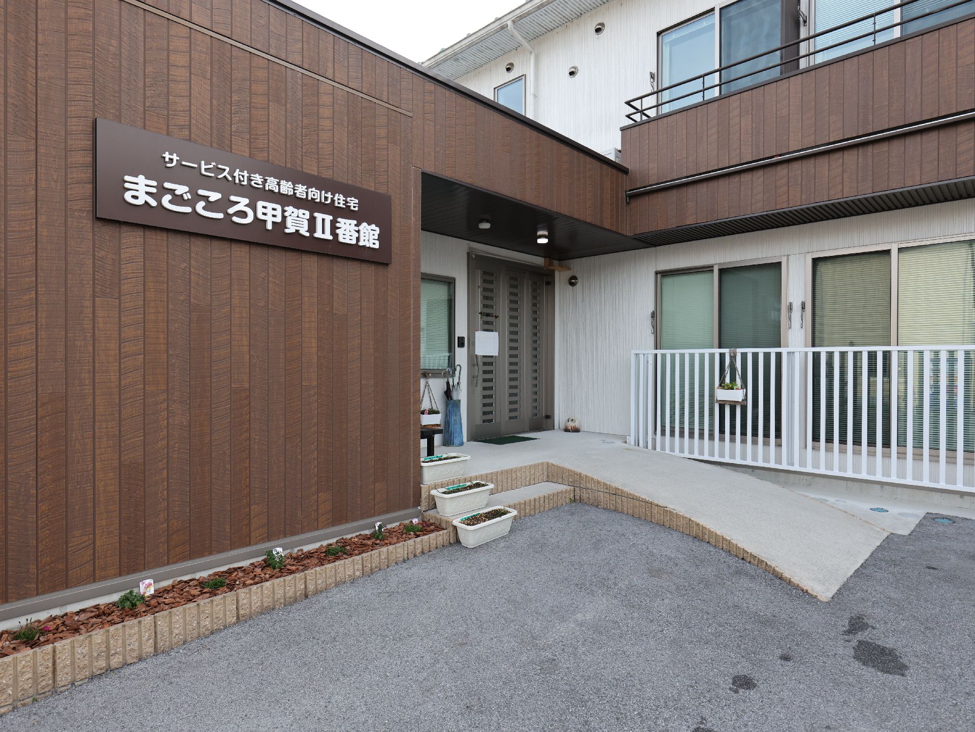 車椅子に座っている高齢女性と寄り添う男性ヘルパー