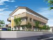 ３階建ての建物は白とベージュで周辺には緑が多くあり、看板にはホーム名が書かれている。