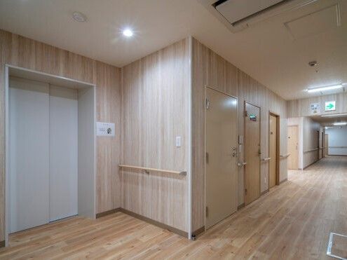 施設内のエレベーター付近を写したもの。手すりがついている廊下