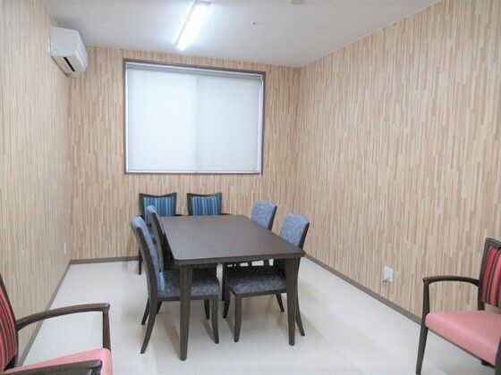 椅子とテーブルが設置されている施設内の談話室。個室仕様の部屋